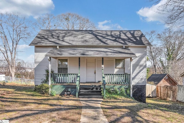 view of front of home featuring a porch and a shed