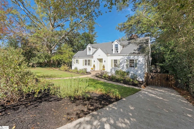 cape cod home featuring a front lawn