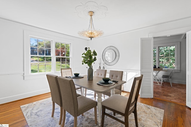 dining space with a chandelier, a healthy amount of sunlight, and dark hardwood / wood-style floors