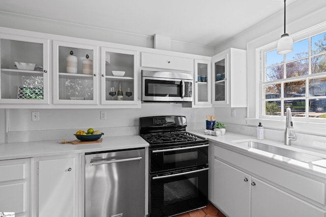 kitchen featuring decorative light fixtures, white cabinetry, appliances with stainless steel finishes, and sink