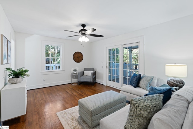 living room featuring ceiling fan and dark hardwood / wood-style floors