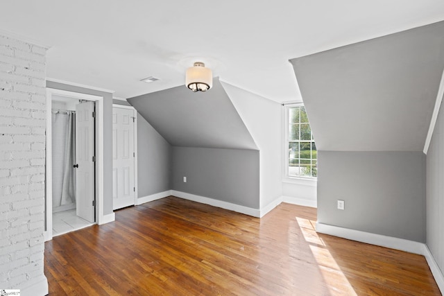 bonus room featuring hardwood / wood-style flooring and vaulted ceiling