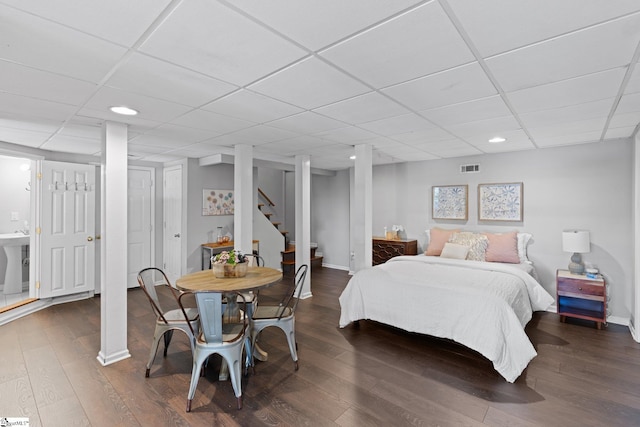 bedroom with dark wood-type flooring and a paneled ceiling