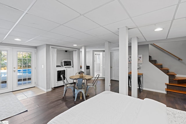 dining room featuring french doors, a paneled ceiling, wood-type flooring, and washing machine and clothes dryer