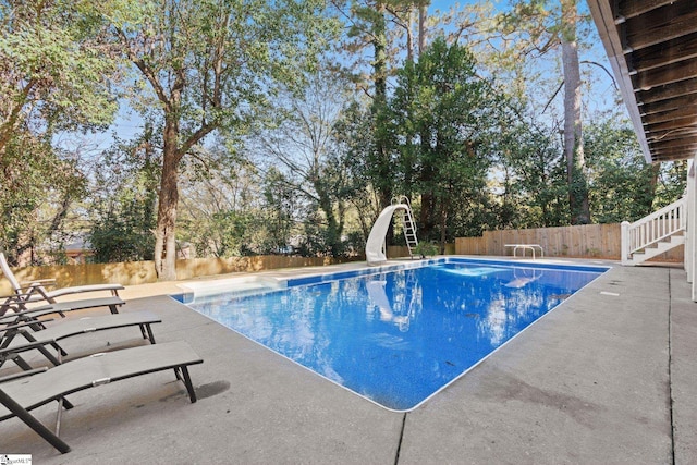 view of pool featuring a diving board, a patio, and a water slide