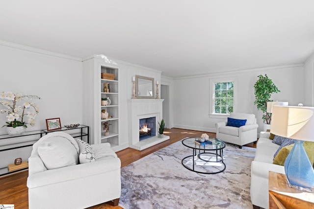 living room featuring built in shelves, hardwood / wood-style floors, and ornamental molding