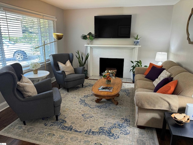 living room featuring a brick fireplace and hardwood / wood-style flooring