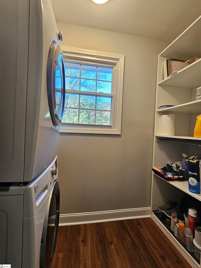 clothes washing area with stacked washing maching and dryer and dark hardwood / wood-style floors