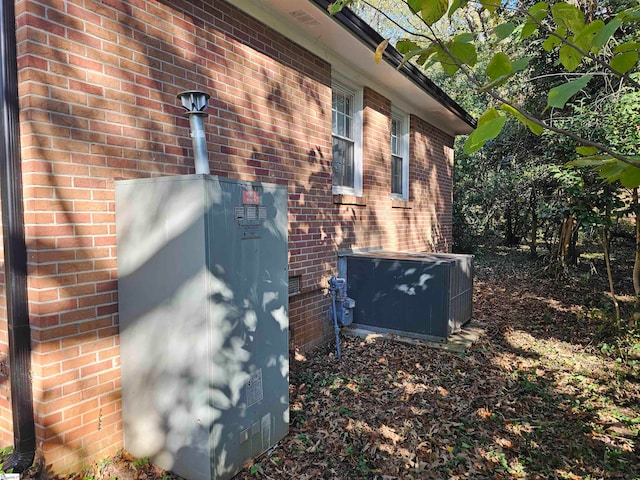 exterior details with central AC unit and a wood stove