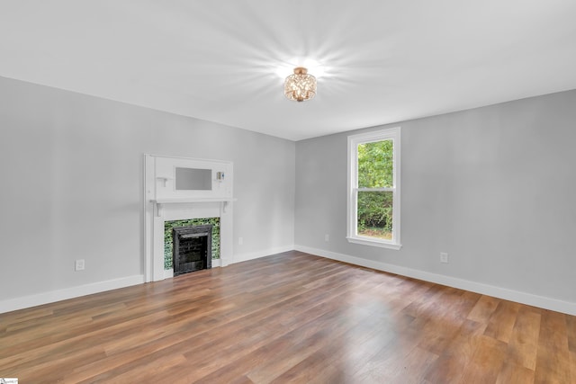 unfurnished living room with hardwood / wood-style flooring and a tile fireplace