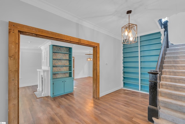 interior space with an inviting chandelier, hardwood / wood-style floors, and ornamental molding