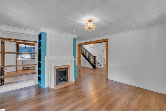 unfurnished living room with ornamental molding, a fireplace, and wood-type flooring