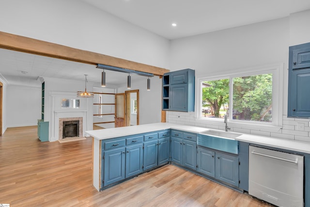 kitchen with decorative backsplash, a brick fireplace, dishwasher, kitchen peninsula, and light hardwood / wood-style flooring