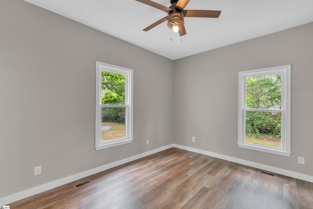 spare room with light wood-type flooring, plenty of natural light, and ceiling fan