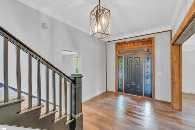 foyer featuring a chandelier, hardwood / wood-style flooring, and ornamental molding