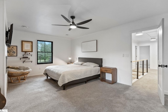 carpeted bedroom with ornamental molding and ceiling fan