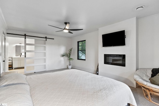 carpeted bedroom featuring a barn door, ceiling fan, and crown molding