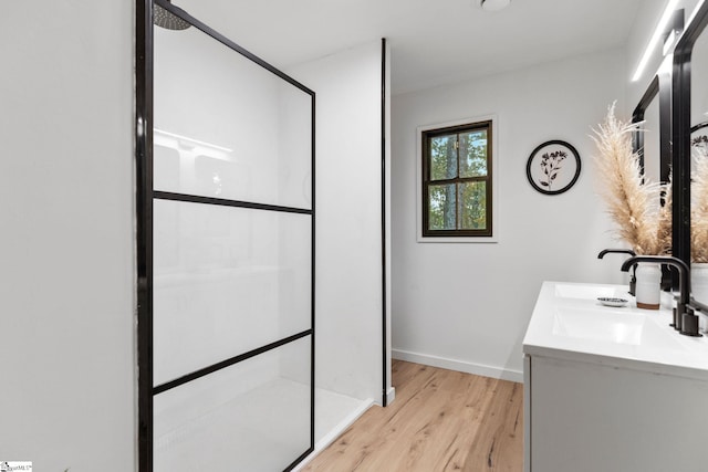 bathroom featuring walk in shower, vanity, and hardwood / wood-style floors