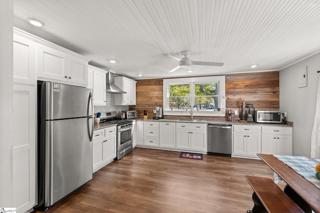 kitchen featuring stainless steel appliances, white cabinetry, sink, wall chimney range hood, and dark hardwood / wood-style flooring