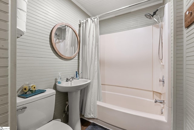 full bathroom featuring wood walls, sink, toilet, and shower / bathtub combination with curtain