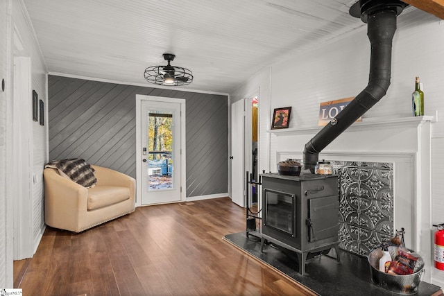 interior space featuring a wood stove, dark hardwood / wood-style flooring, and wood walls