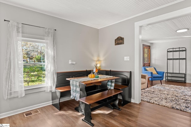 dining space featuring hardwood / wood-style flooring and crown molding