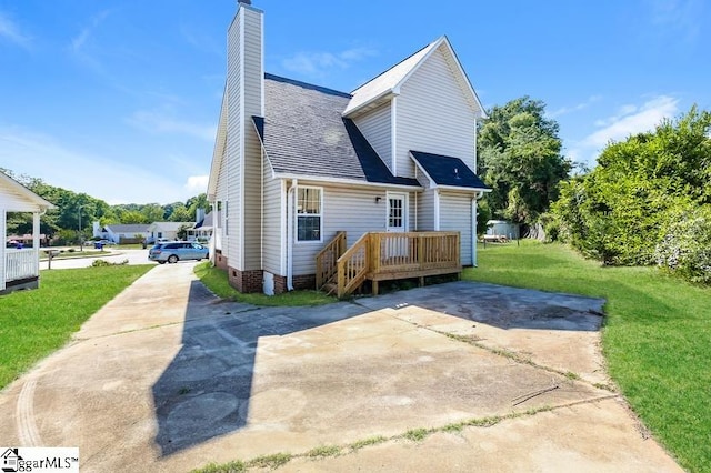 back of house featuring a lawn and a wooden deck