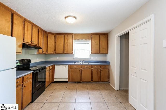 kitchen featuring light tile patterned flooring, white appliances, and sink