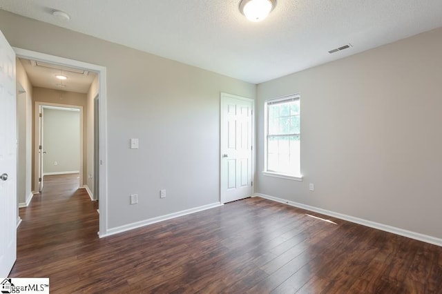 unfurnished bedroom with dark wood-type flooring and a textured ceiling