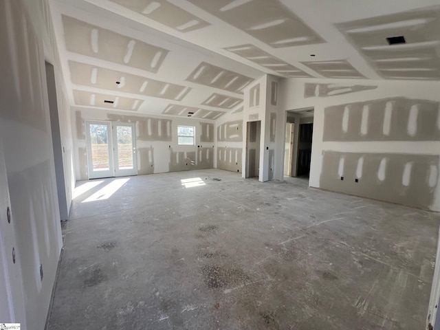 unfurnished living room with french doors and lofted ceiling