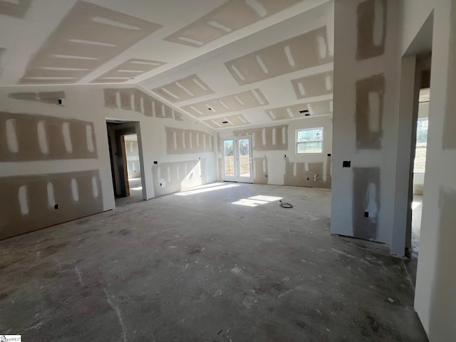 unfurnished living room featuring concrete floors and lofted ceiling