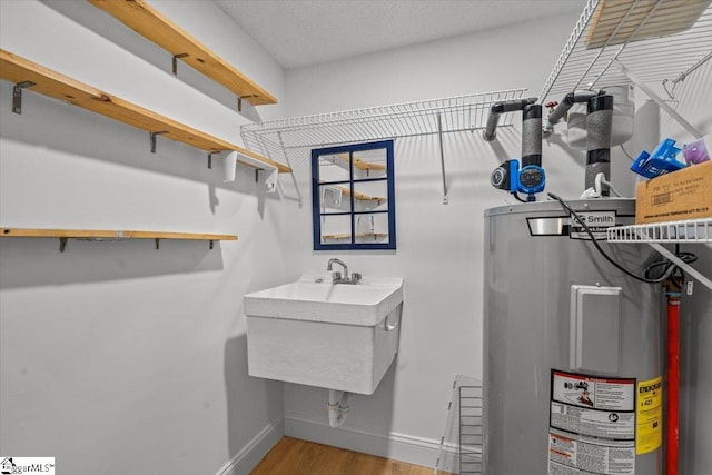 utility room featuring sink and electric water heater