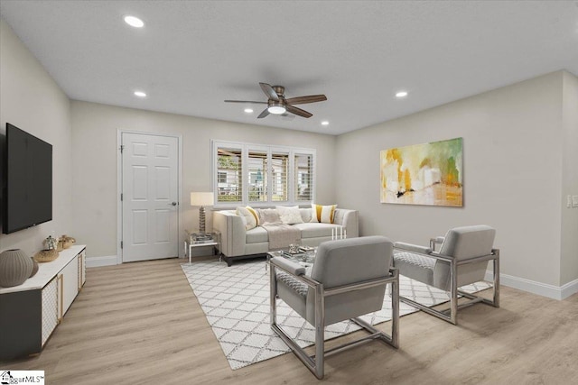 living room featuring ceiling fan and light hardwood / wood-style floors