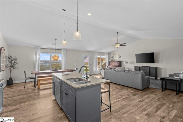 kitchen featuring hardwood / wood-style flooring, vaulted ceiling, gray cabinetry, and sink