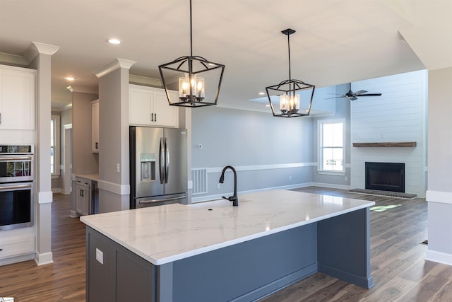 kitchen featuring hanging light fixtures, white cabinets, appliances with stainless steel finishes, and dark hardwood / wood-style flooring