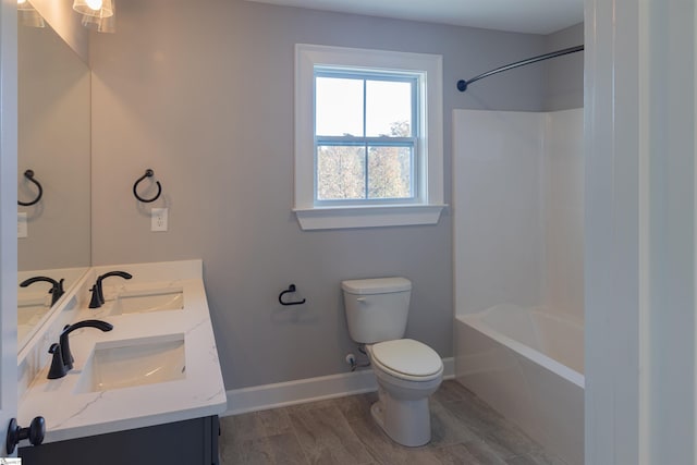 full bathroom with washtub / shower combination, toilet, vanity, and hardwood / wood-style flooring