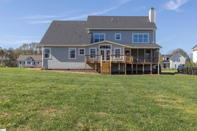 rear view of property featuring a yard, a sunroom, and a deck