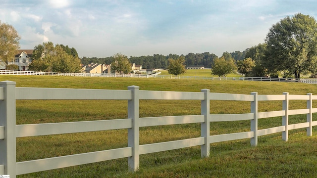 view of gate featuring a rural view and a lawn