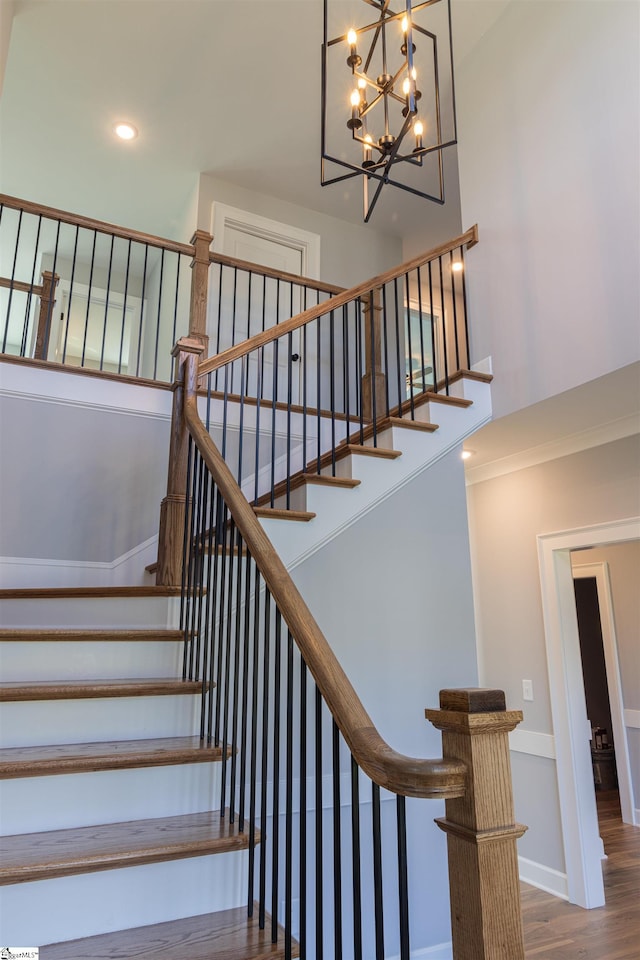 stairway with a chandelier and hardwood / wood-style flooring