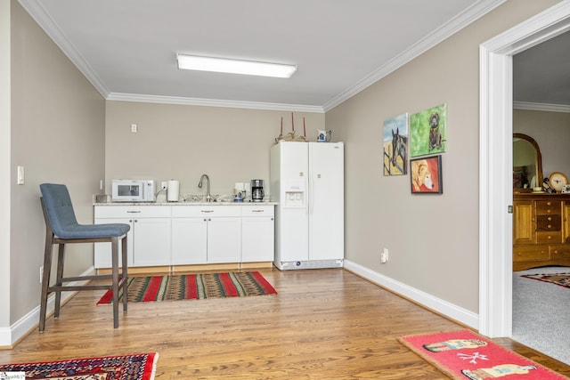 bar with crown molding, light hardwood / wood-style flooring, white cabinets, and white appliances