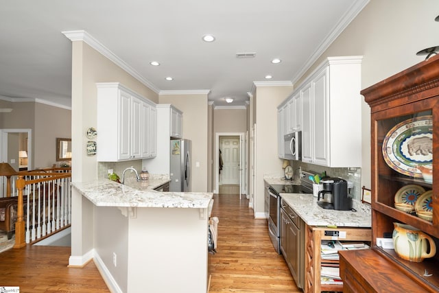 kitchen featuring decorative backsplash, white cabinetry, light hardwood / wood-style floors, and appliances with stainless steel finishes