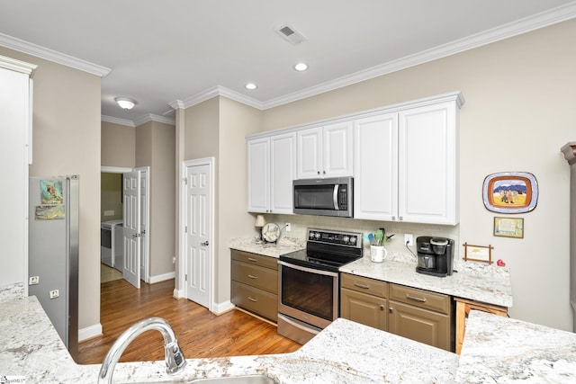 kitchen featuring white cabinetry, tasteful backsplash, light hardwood / wood-style flooring, crown molding, and appliances with stainless steel finishes