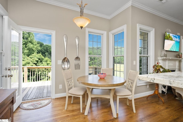 dining room featuring a wealth of natural light, wood-type flooring, and crown molding