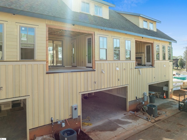 rear view of property featuring board and batten siding and a shingled roof