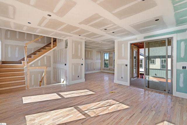 spare room featuring stairs, wood finished floors, and baseboards