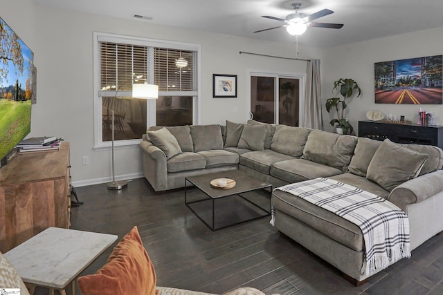 living room with dark hardwood / wood-style flooring, ceiling fan, and a barn door