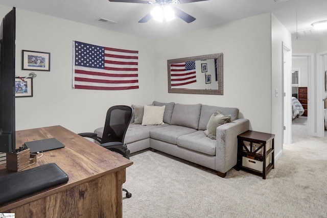 carpeted home office featuring ceiling fan