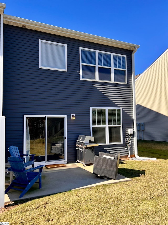 rear view of property featuring a lawn and a patio area