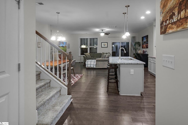 kitchen featuring a kitchen breakfast bar, an island with sink, decorative light fixtures, and sink