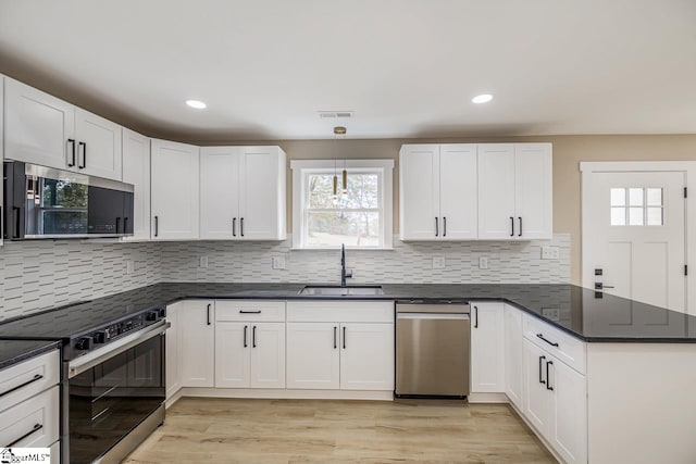 kitchen featuring white cabinets, light hardwood / wood-style floors, and appliances with stainless steel finishes